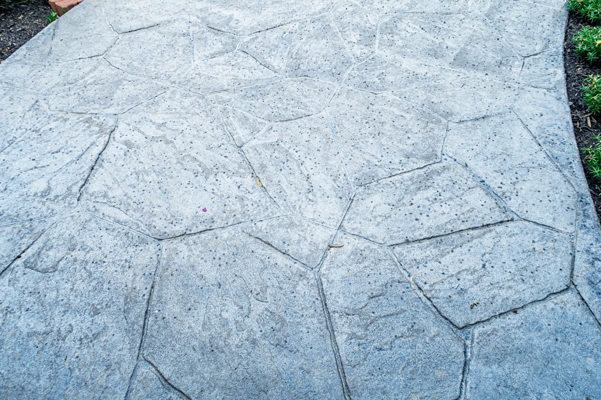 First Rain Storm Raindrops Scattered on Concrete Footpath